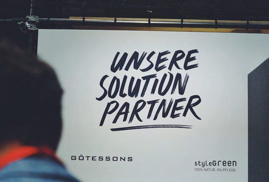 Handgeschriebenes „Unsere Solution Partner“ auf heller Wand