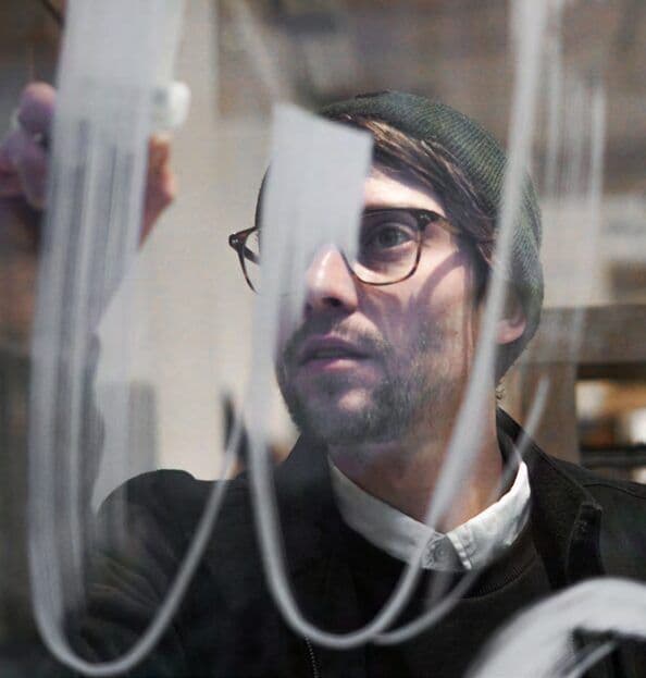 Markus Olson malt Lettering direkt auf eine Glasscheibe